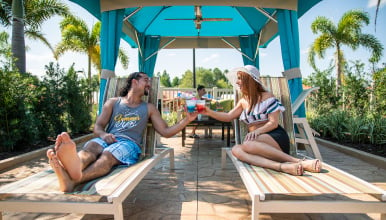 Man and woman toasting with tropical drinks in a private cabana